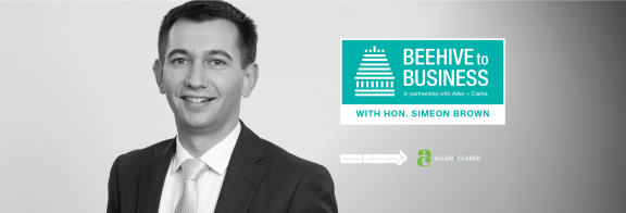 Minister Brown smiles for the camera, while wearing a suit. Image shows title reading: "Beehive to Business"